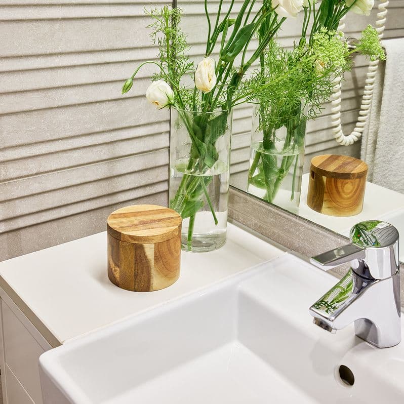 Lavabo minimalista con florero y decoración natural en baño de Edificio Calle Juristas