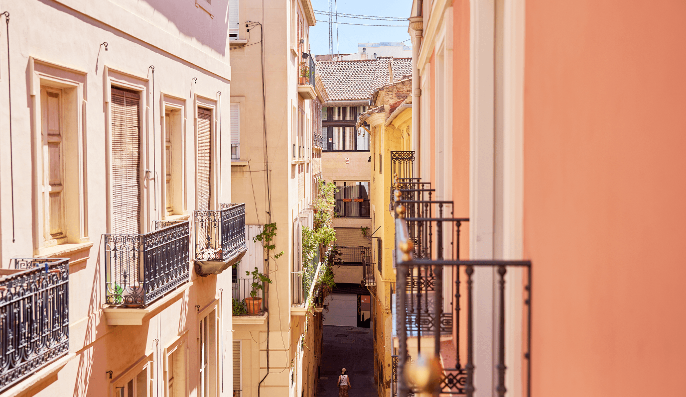 Vista de calle estrecha en Ciutat Vella con balcones de hierro forjado y fachadas en tonos pastel desde Edificio Calle Juristas